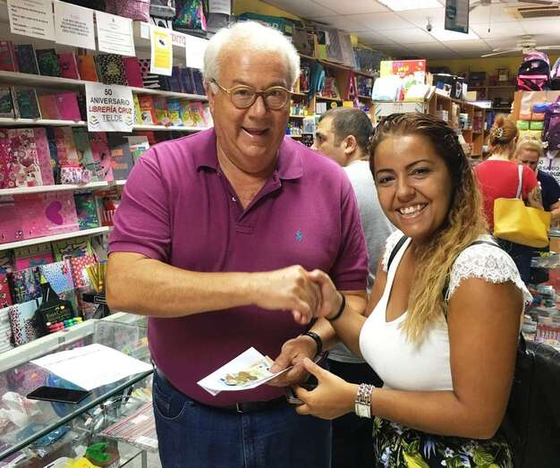 Momento en que Mauricio Cruz, propietario de la librería, entrega a la ganadora el premio en metálico (Foto TA)